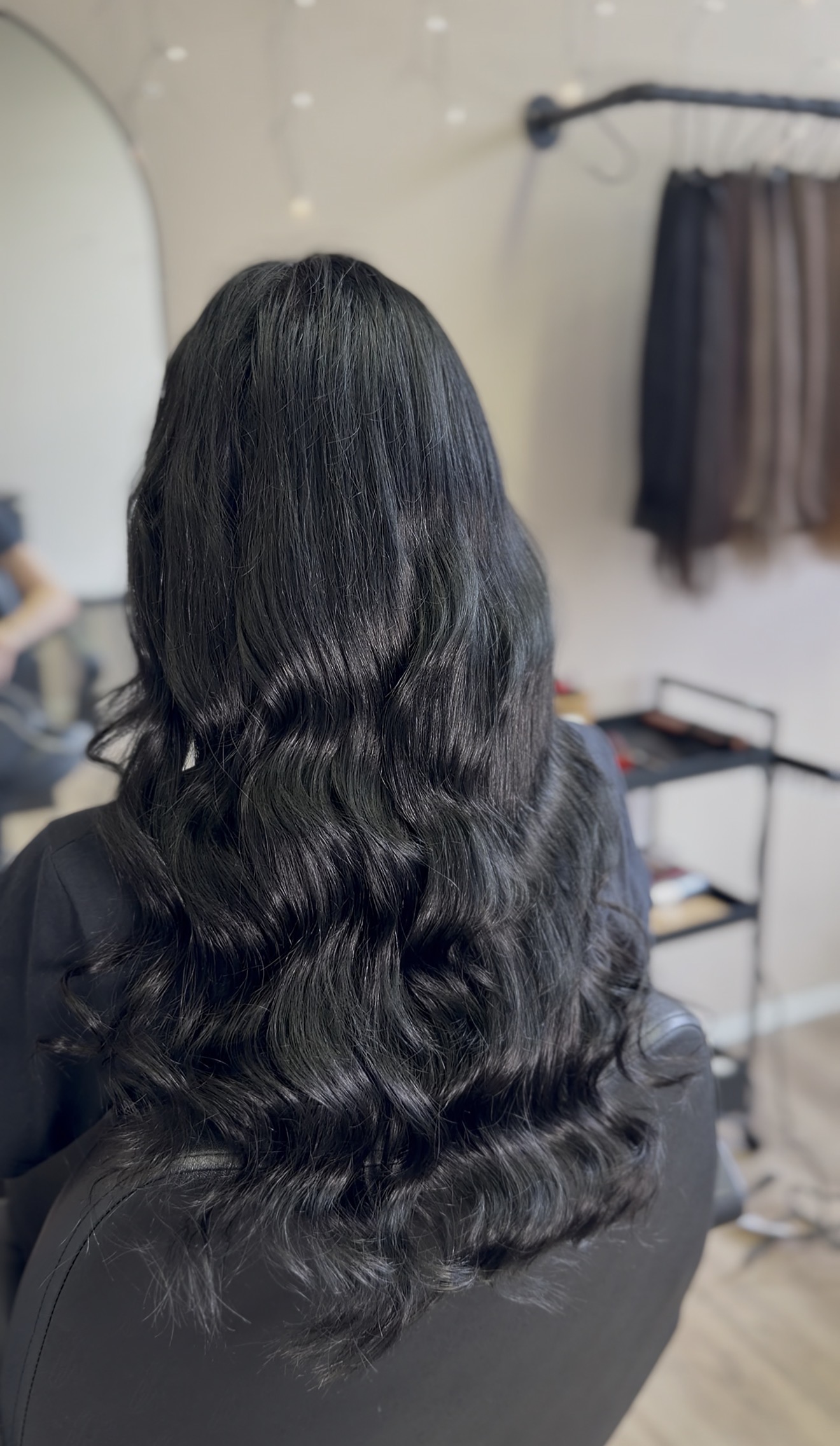 Lange donkere haar extensions met golven, van achteren